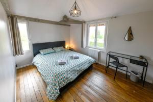 a bedroom with a bed and a chair in it at Domaine le Colombier in Dienville