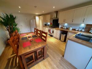 a kitchen with a wooden table with chairs and a counter at Yucca cottage in Kendal