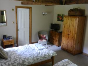 a bedroom with a bed and a desk and a television at The Old Mill in Wooler
