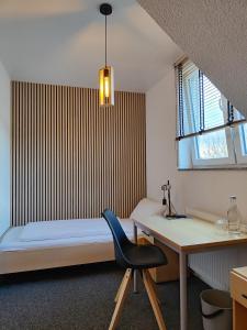 um quarto com uma cama, uma secretária e uma cadeira em Haus des Sports em Bad Kreuznach
