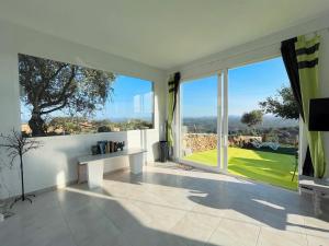 a room with a large window with a table and a television at El Coso Lodge & Workation in Zalamea la Real