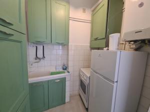 a kitchen with green cabinets and a white refrigerator at Casa Patrizia by PortofinoVacanze in Rapallo +49 photos