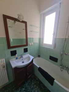 a bathroom with a sink and a tub and a mirror at Casa Patrizia by PortofinoVacanze in Rapallo