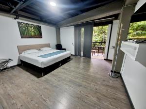 1 dormitorio con 1 cama y suelo de madera en Alojamiento Carriquí, en Pereira
