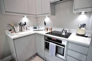 a kitchen with white cabinets and a stove top oven at Sea View I High Ceiling I Next to Brighton Beach in Brighton & Hove