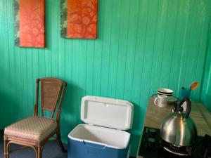 a green wall with a chair and a sink and a table at Simple Rustic studio deluxe bed in tropical fruits garden in Mountain View