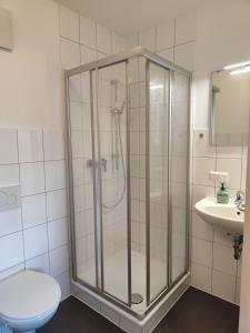 een badkamer met een douche, een toilet en een wastafel bij Haus des Sports in Bad Kreuznach