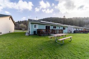 einen Picknicktisch in einem Hof vor einem Haus in der Unterkunft Elk Meadow Cabins 13A Bears Den Suite in Orick