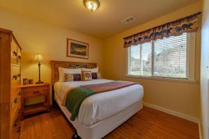 Schlafzimmer mit einem Bett und einem Fenster in der Unterkunft Elk Meadow Cabins 13A Bears Den Suite in Orick