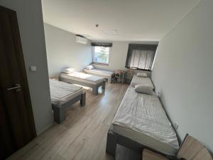 a room with three beds and a living room at Noclegi Europol in Siemianowice Śląskie