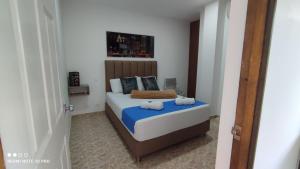 a bedroom with a bed with two towels on it at Finca Hotel Zona Franca in Rionegro