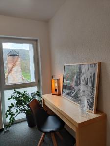 a desk with a picture and a chair and a window at Haus des Sports in Bad Kreuznach