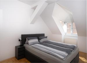 a bed in a white room with a window at Apartment inmitten der Stadt Leoben. in Leoben