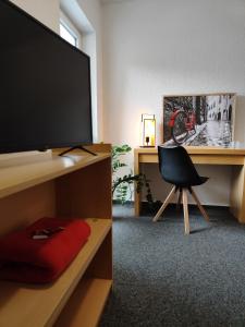 een kamer met een bureau, een televisie en een stoel bij Haus des Sports in Bad Kreuznach