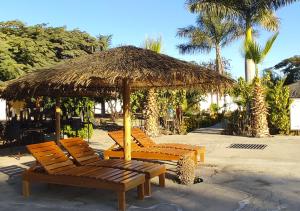 un groupe de chaises sous un parasol dans l'établissement Nazca Lodge, à Nazca