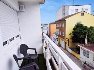 einen Stuhl auf dem Balkon eines Gebäudes in der Unterkunft PISO RAPADOIRA in Foz