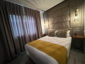 una camera d'albergo con un grande letto e una finestra di Hotel Art Santander a Santander