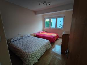 1 Schlafzimmer mit 2 Betten und einem Fenster in der Unterkunft PISO RAPADOIRA in Foz