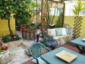 un patio con tavolo e alcune piante e fiori di B&B da Anna a Bosa
