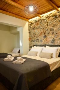 two beds in a room with a stone wall at Verga Paradise Nest - A Blissful Hideout in Almirón