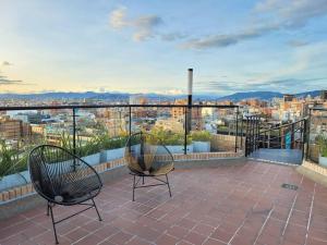 - deux chaises sur un balcon avec vue sur la ville dans l'établissement 812 Elevated Escape Loft, à Bogotá