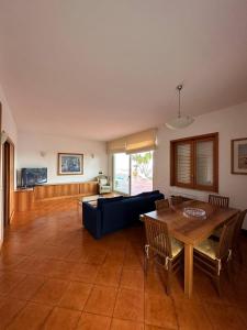 ein Wohnzimmer mit einem blauen Sofa und einem Tisch in der Unterkunft Holiday flower villa panoramica sul golfo di Catania in Misterbianco
