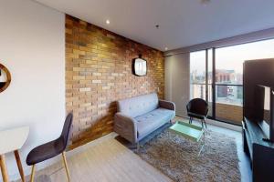 - un salon avec un canapé et un mur en briques dans l'établissement 812 Elevated Escape Loft, à Bogotá