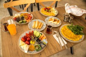 a wooden table topped with plates of food and fruit at Ephesus Hera in Selcuk