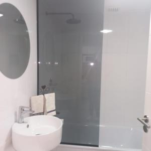 a bathroom with a shower and a white sink at Torres Brickell Departamento -MALVAN- 1A in Tigre