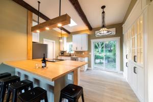 a kitchen with a large wooden island with stools at Cozy Cabin Suites, Sooke, Bc in Sooke