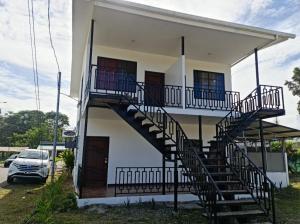a house with a staircase on the side of it at El Rincon in Cahuita