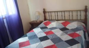 um quarto com uma cama com uma colcha xadrez em AIMA em Villa Giardino