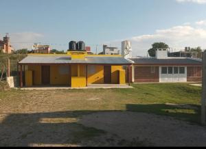 uma casa amarela com um grande quintal com um edifício em AIMA em Villa Giardino
