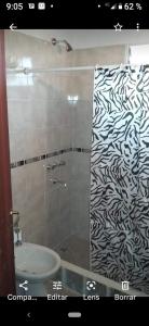uma casa de banho com um chuveiro com um padrão preto e branco em AIMA em Villa Giardino