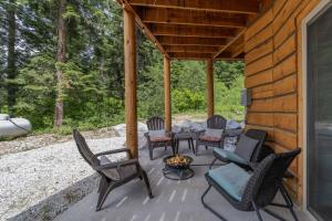 eine Terrasse mit Stühlen und einer Feuerstelle in einer Hütte in der Unterkunft Bearfoot Chalet by NW Comfy Cabins in Leavenworth
