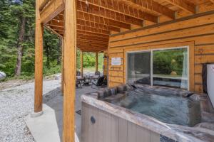 a wooden cabin with a hot tub in it at Bearfoot Chalet by NW Comfy Cabins in Leavenworth