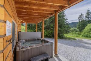 a hot tub on the back of a wooden building at Bearfoot Chalet by NW Comfy Cabins in Leavenworth