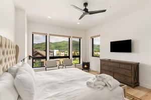 Un dormitorio blanco con una cama y un televisor de pantalla plana. en Traverse 1448, en Steamboat Springs