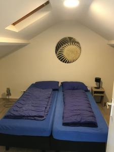 een slaapkamer met 2 bedden en een ventilator aan de muur bij Adorable two bedroom bungalow C7 next to hotel. in Garderen