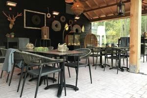 a group of tables and chairs on a patio at Adorable two bedroom bungalow C7 next to hotel. in Garderen