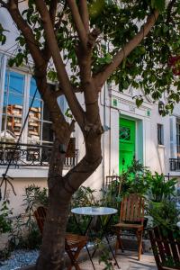 una mesa y sillas junto a un árbol con una puerta verde en Yogi hostel boutique, en Santiago