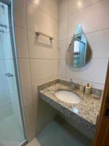 y baño con lavabo y espejo. en Vila beija-flor prime / apt 02 en Mucugê