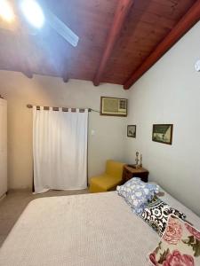 - une chambre avec un lit et un canapé jaune dans l'établissement quinta iaia, à Villaguay