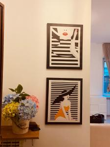 three framed pictures on a wall with a vase of flowers at Casa Vittorio in Turin