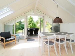 a white dining room with a table and chairs at Holiday home Vejby XLIII in Vejby