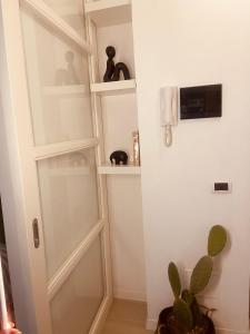 una habitación con una puerta de cristal y una planta en Casa Vittorio, en Turín