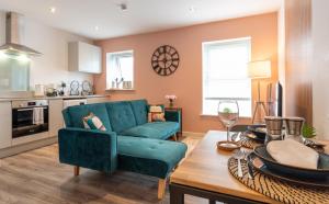 ein Wohnzimmer mit einem blauen Sofa und einem Tisch in der Unterkunft Stylish, One-Bedroom Flat in Harrogate Town Centre in Harrogate