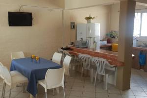 a dining room with a table and chairs and a kitchen at Amplia casa en Tonsupa con piscina privada y WIFI in Tonsupa