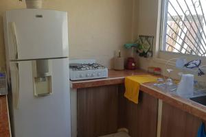 uma cozinha com um frigorífico branco e uma janela em Amplia casa en Tonsupa con piscina privada y WIFI em Tonsupa