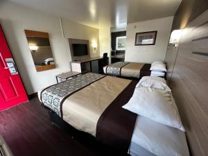 ein Hotelzimmer mit 2 Betten und einem Spiegel in der Unterkunft Budget Inn Nassawadox in Nassawadox